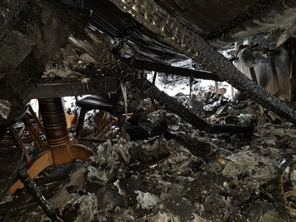 Collapsed, fire-charred room contents after a New Hampshire house fire